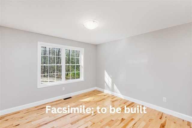 empty room featuring visible vents, baseboards, and wood finished floors