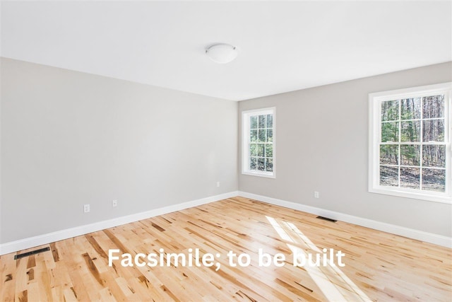 unfurnished room with visible vents, baseboards, and wood finished floors