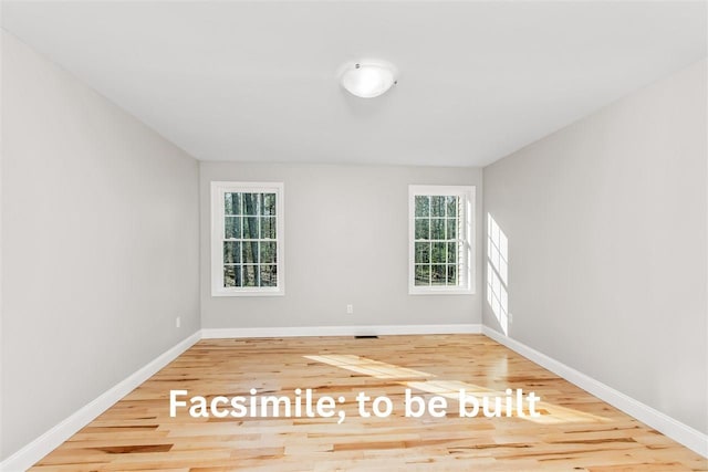 unfurnished room with baseboards and wood finished floors