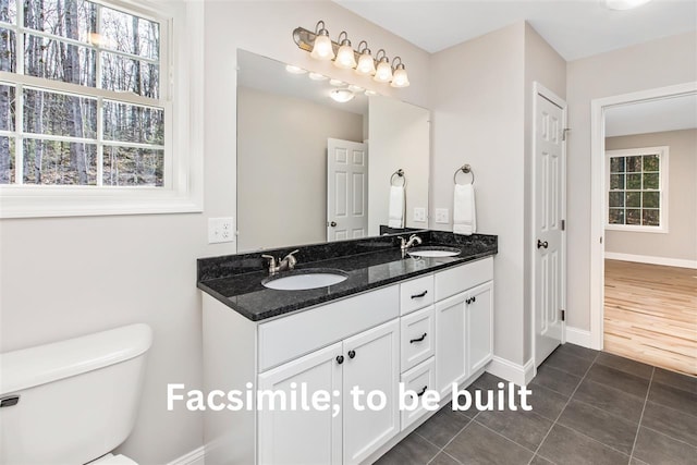 bathroom with double vanity, tile patterned flooring, toilet, and a sink