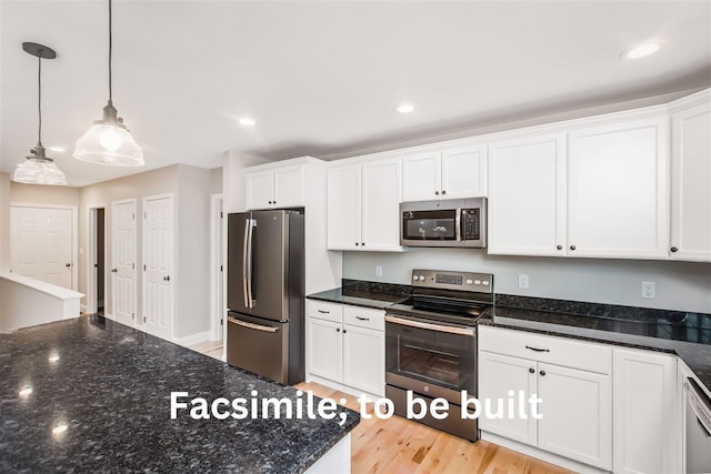 kitchen with dark stone countertops, appliances with stainless steel finishes, and white cabinets