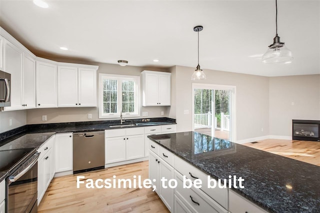 kitchen with a sink, appliances with stainless steel finishes, and white cabinetry