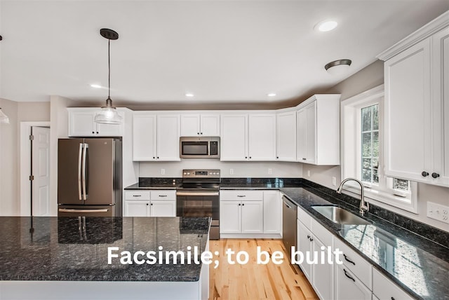 kitchen featuring recessed lighting, appliances with stainless steel finishes, white cabinetry, and a sink