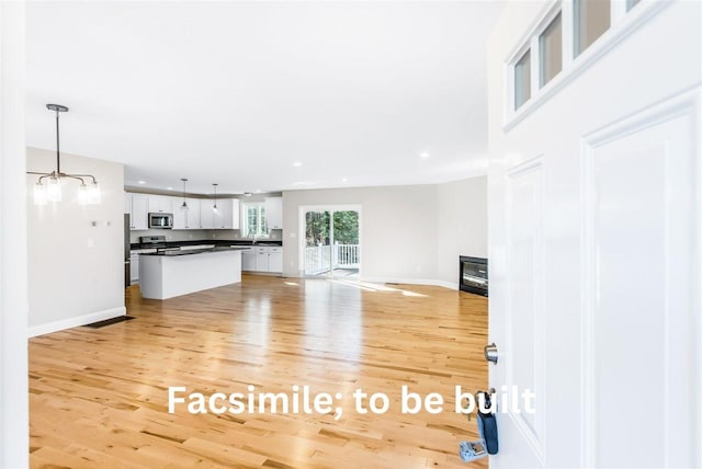 unfurnished living room featuring light wood-style flooring, recessed lighting, and baseboards