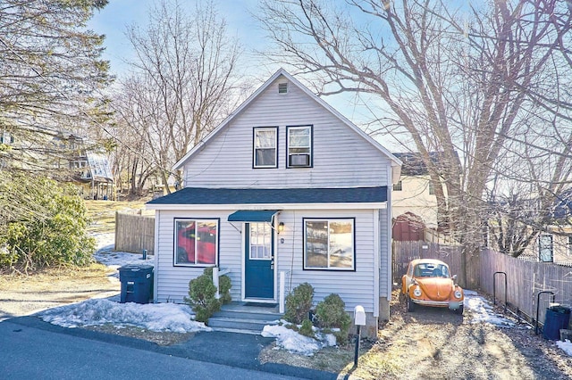 bungalow-style house featuring a shingled roof, driveway, and fence