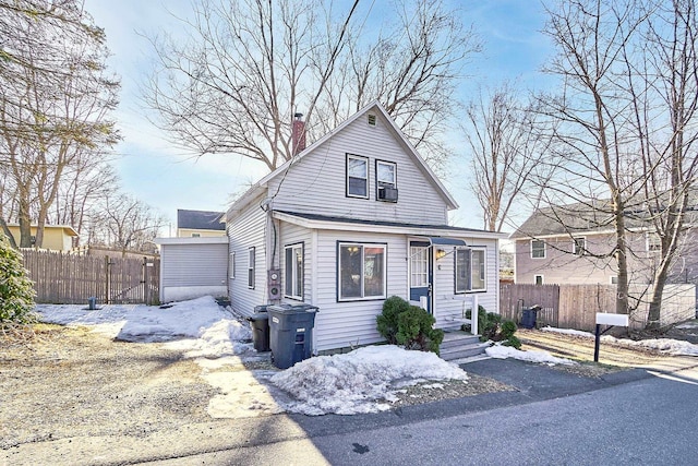 bungalow-style home featuring fence and a chimney