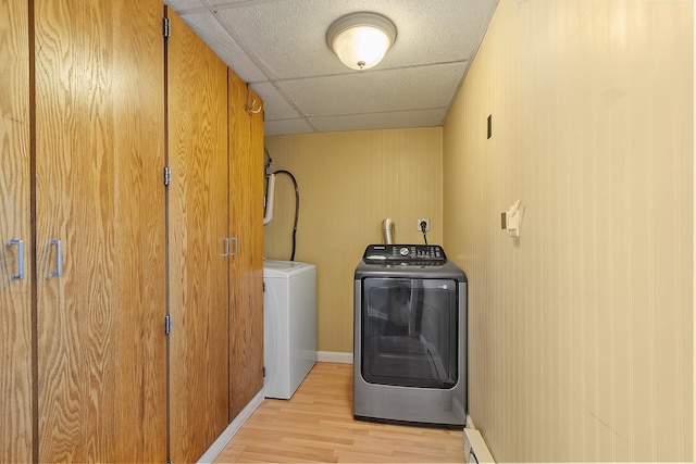 laundry area featuring washer and dryer, baseboards, light wood-style floors, and laundry area