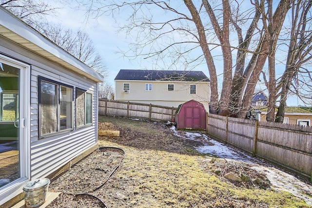 view of yard with an outdoor structure, a storage shed, and a fenced backyard