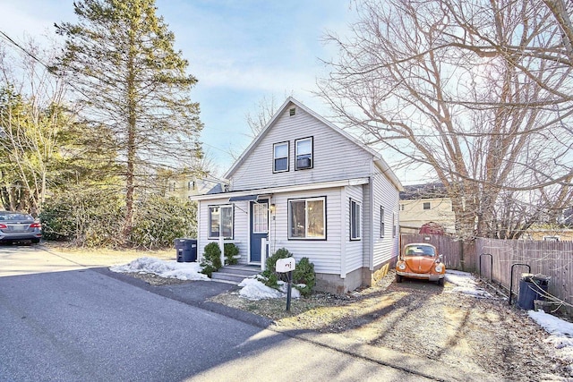 bungalow-style home with driveway and fence