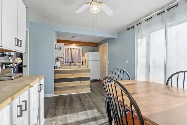 kitchen featuring wooden counters, white cabinetry, dark wood finished floors, and freestanding refrigerator