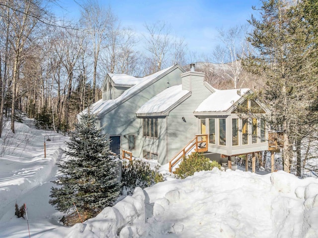 view of snowy exterior with a chimney