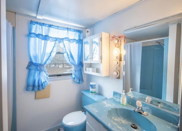 bathroom featuring a shower with shower curtain, toilet, and vanity