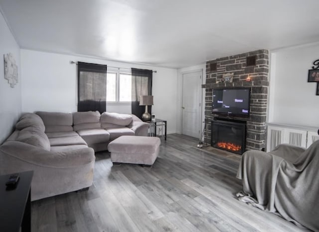 living room featuring a stone fireplace and wood finished floors