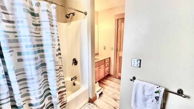 bathroom featuring shower / bath combo with shower curtain, wood finished floors, and vanity