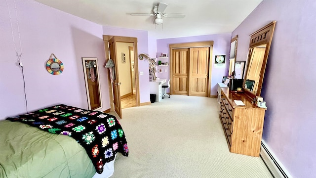 carpeted bedroom with a baseboard radiator, baseboards, a closet, and a ceiling fan