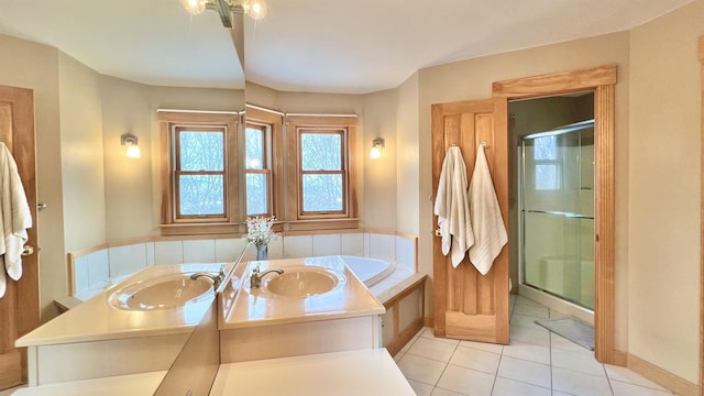 full bath featuring a sink, a garden tub, a shower stall, and tile patterned flooring