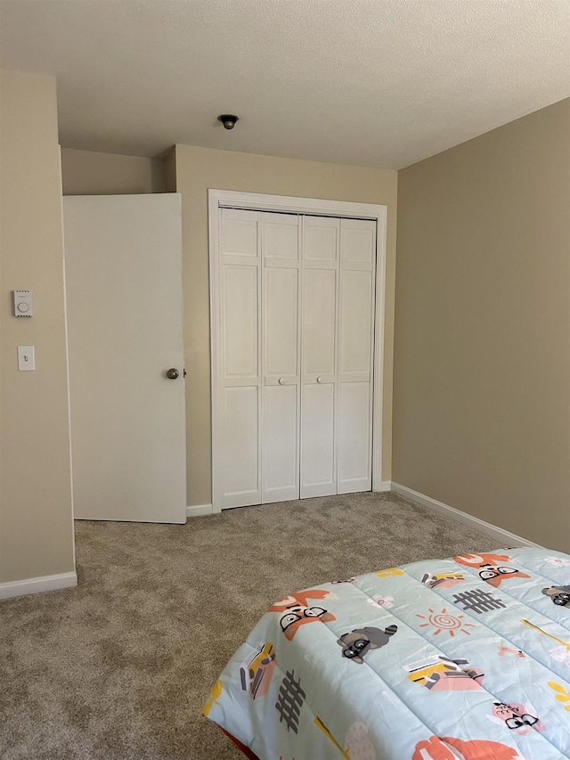 unfurnished bedroom with a closet, carpet flooring, and baseboards