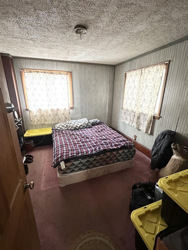 carpeted bedroom with ornamental molding and a textured ceiling