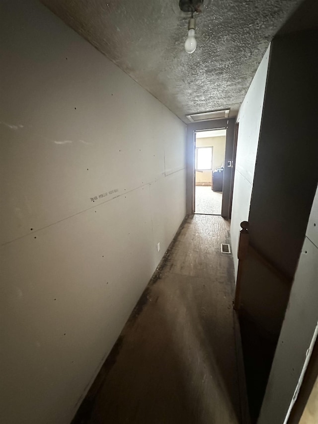 hallway with visible vents and a textured ceiling