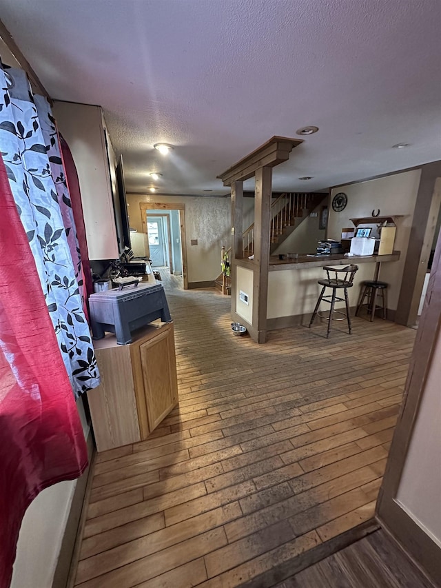 interior space with dark wood-style floors, stairway, a textured ceiling, and baseboards