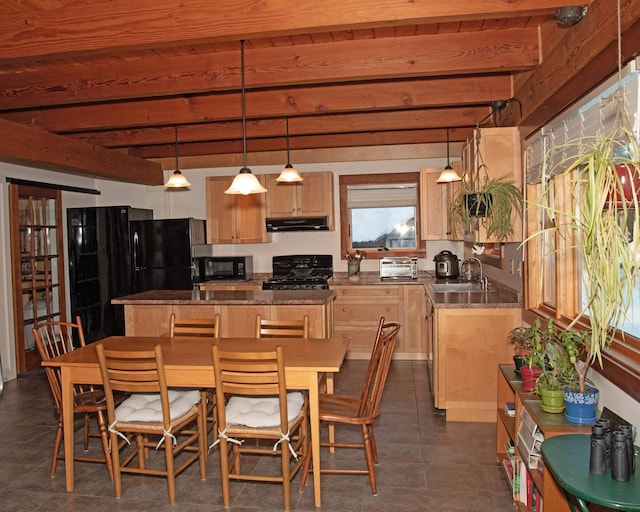 kitchen with a center island, under cabinet range hood, beam ceiling, black appliances, and a sink