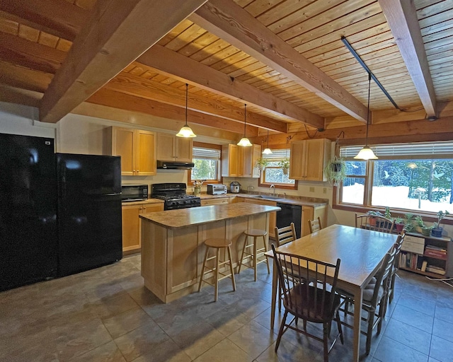 kitchen featuring light brown cabinets, a sink, black appliances, under cabinet range hood, and a center island