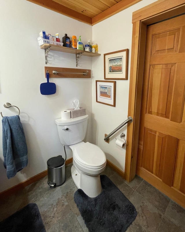 bathroom featuring baseboards and toilet