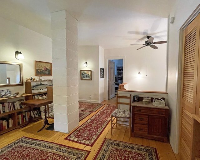 corridor with ornate columns and light wood finished floors