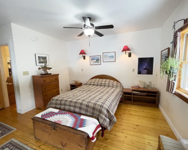 bedroom with baseboards, light wood-type flooring, and ceiling fan