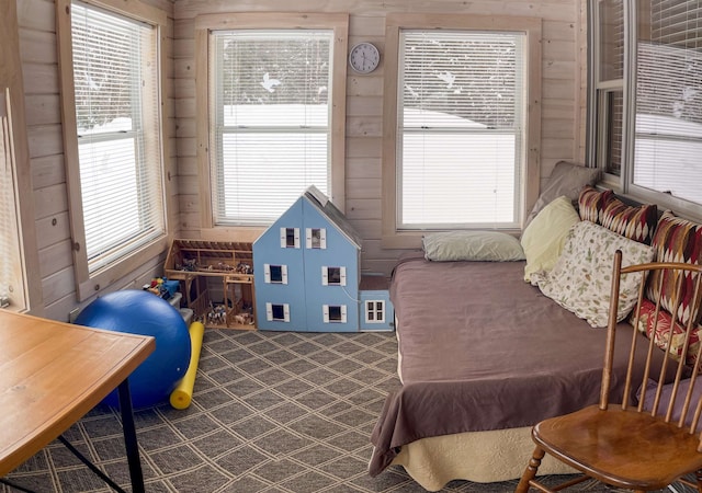 bedroom with wooden walls and dark colored carpet