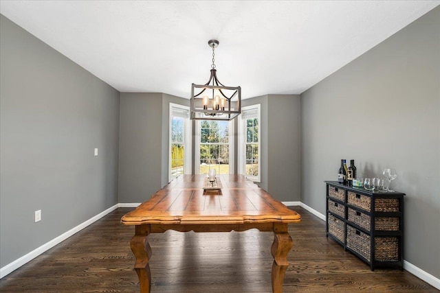 dining area with a chandelier, baseboards, and dark wood-style floors