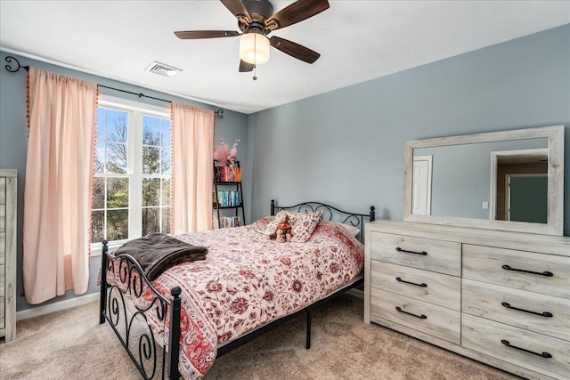 bedroom featuring a ceiling fan, light colored carpet, and visible vents