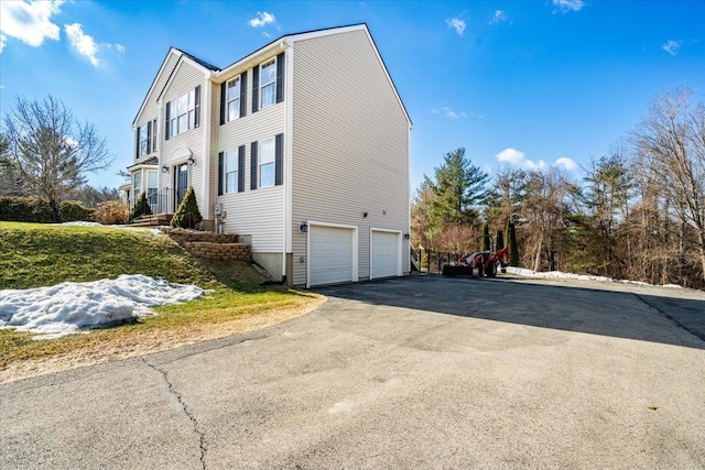 view of side of home with an attached garage and driveway