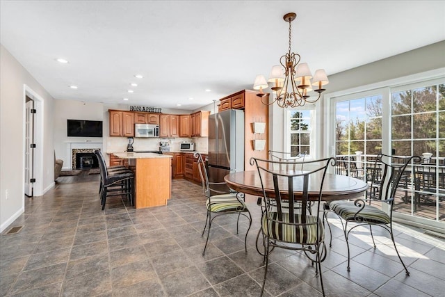 dining space featuring a glass covered fireplace, recessed lighting, baseboards, and visible vents