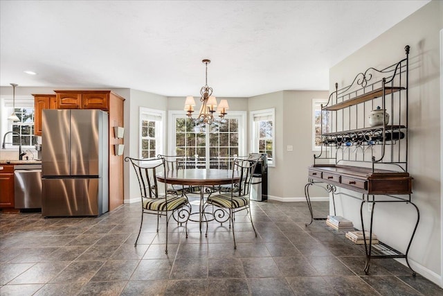 dining space with baseboards and a notable chandelier