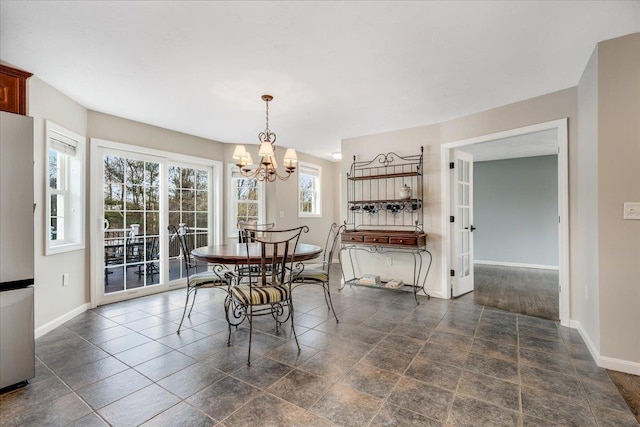 dining area with baseboards and an inviting chandelier