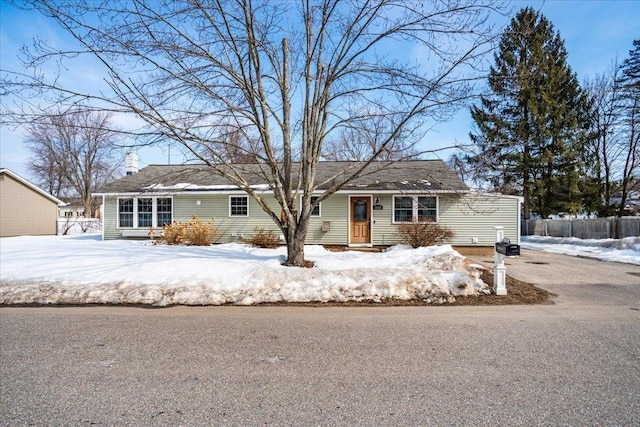 ranch-style home featuring fence