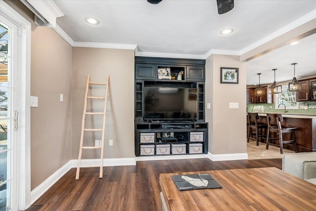 living area featuring dark wood-type flooring, baseboards, and ornamental molding