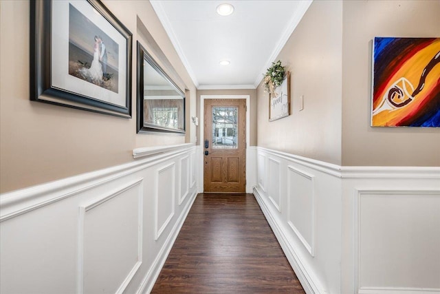 doorway with dark wood finished floors, recessed lighting, a decorative wall, wainscoting, and crown molding