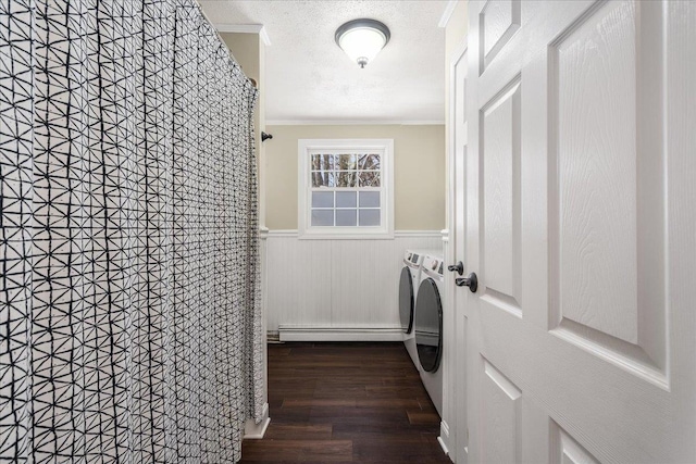 laundry room with a wainscoted wall, baseboard heating, laundry area, washer and dryer, and a textured ceiling