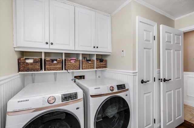 washroom with washer and dryer, a wainscoted wall, and cabinet space