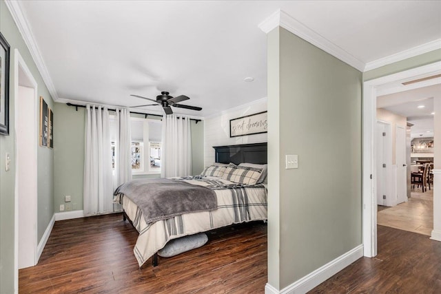 bedroom with crown molding, wood finished floors, and baseboards