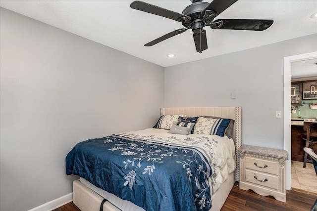 bedroom with wood finished floors, baseboards, and ceiling fan