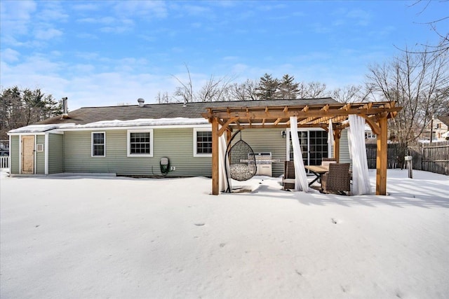 snow covered property with a patio area, fence, and a pergola