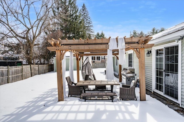 snow covered patio with outdoor dining space, area for grilling, fence, and a pergola