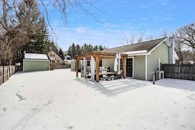 back of property featuring a pergola, a fenced backyard, a storage shed, an outdoor structure, and a garage