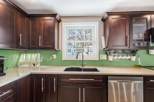 kitchen with a sink, dark brown cabinetry, glass insert cabinets, light stone countertops, and dishwasher