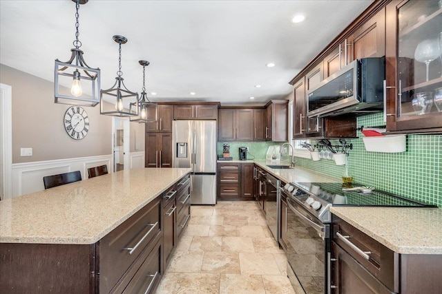 kitchen featuring a sink, a kitchen island, dark brown cabinetry, and appliances with stainless steel finishes