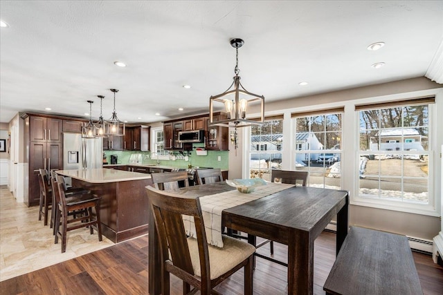 dining area with recessed lighting, an inviting chandelier, and wood finished floors