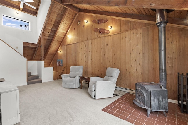 sitting room featuring wooden walls, carpet floors, a wood stove, stairs, and wood ceiling